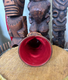 top view of a slipcase brown ceramic tiki mug with a detailed face, green leaves, and gold accents.